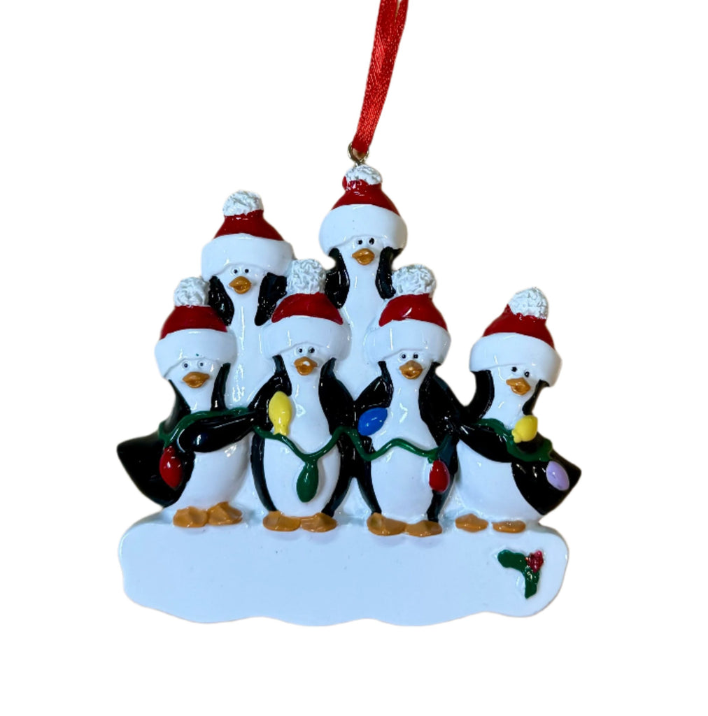 a christmas ornament with penguins wearing santa hats and holding christmas lights
