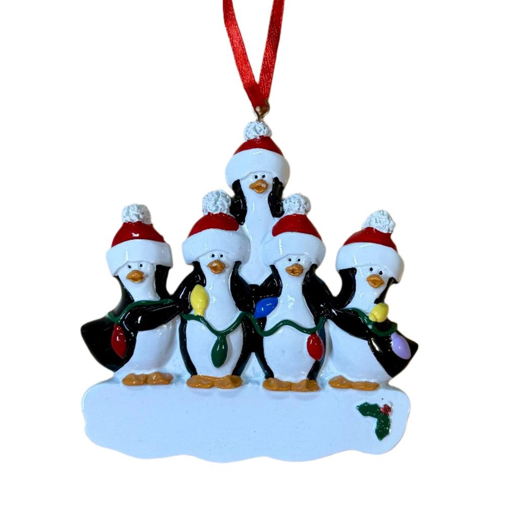 a christmas ornament with penguins wearing santa hats and holding christmas lights