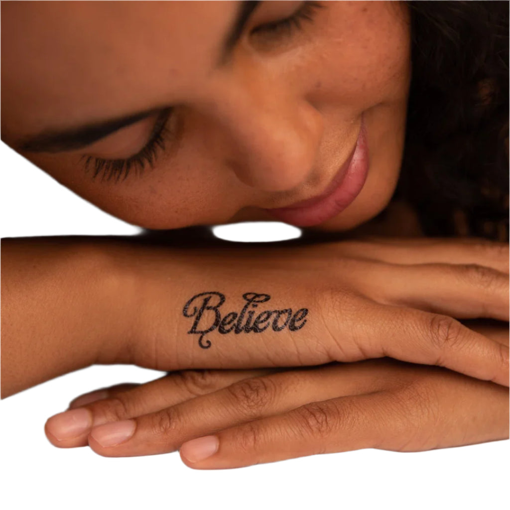 a woman has the word believe tattooed on her wrist