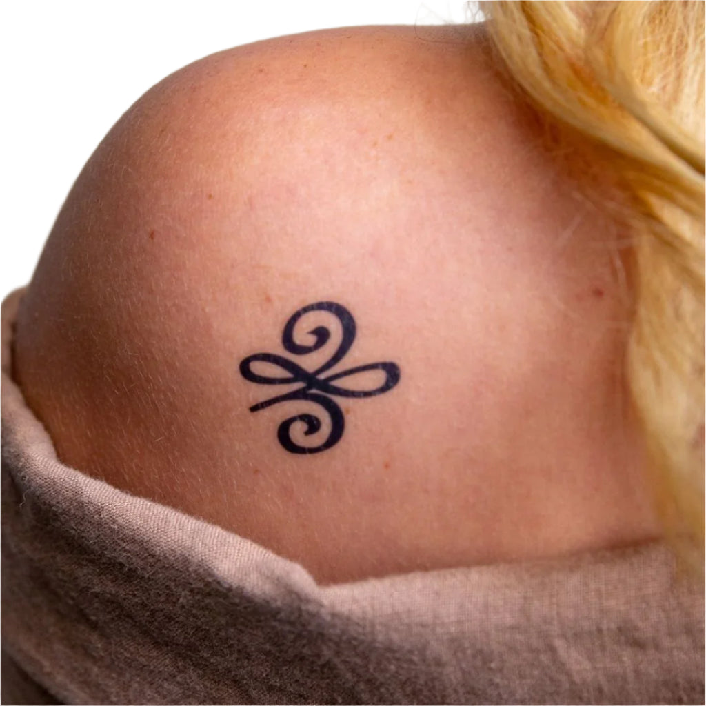 a woman has a small tattoo on her shoulder