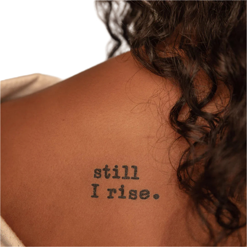 a woman has a tattoo on her back that says still i rise